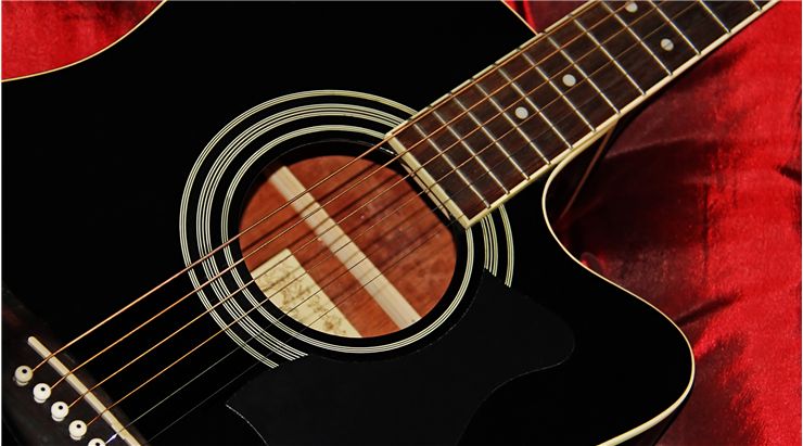 Black Acoustic Guitar on a Red Satin Background